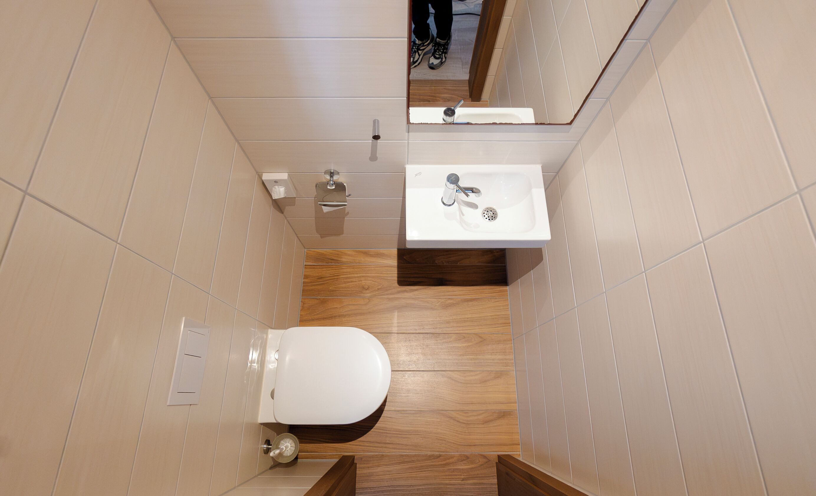 Een kleine badkamer met toilet, wastafel en spiegel.
