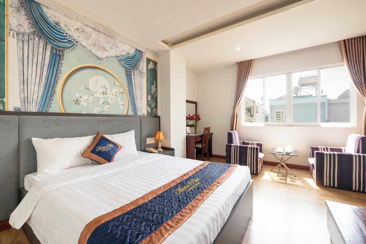 Une chambre d’hôtel avec un grand lit, un bureau, une chaise et un canapé.