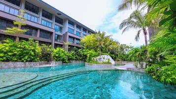Relax by the serene pool surrounded by lush greenery and modern architecture.