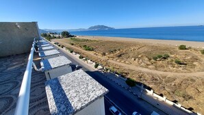A coastal road with a view of the sea and a distant mountain. - Hotel Blador (Tichy)