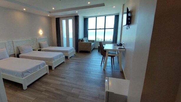 A hotel room with two single beds, a desk, and a chair. - Hotel Blador (Tichy)