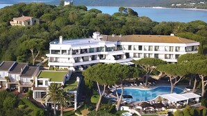 Un resort grande y moderno con varias construcciones, una piscina y abundante vegetación.