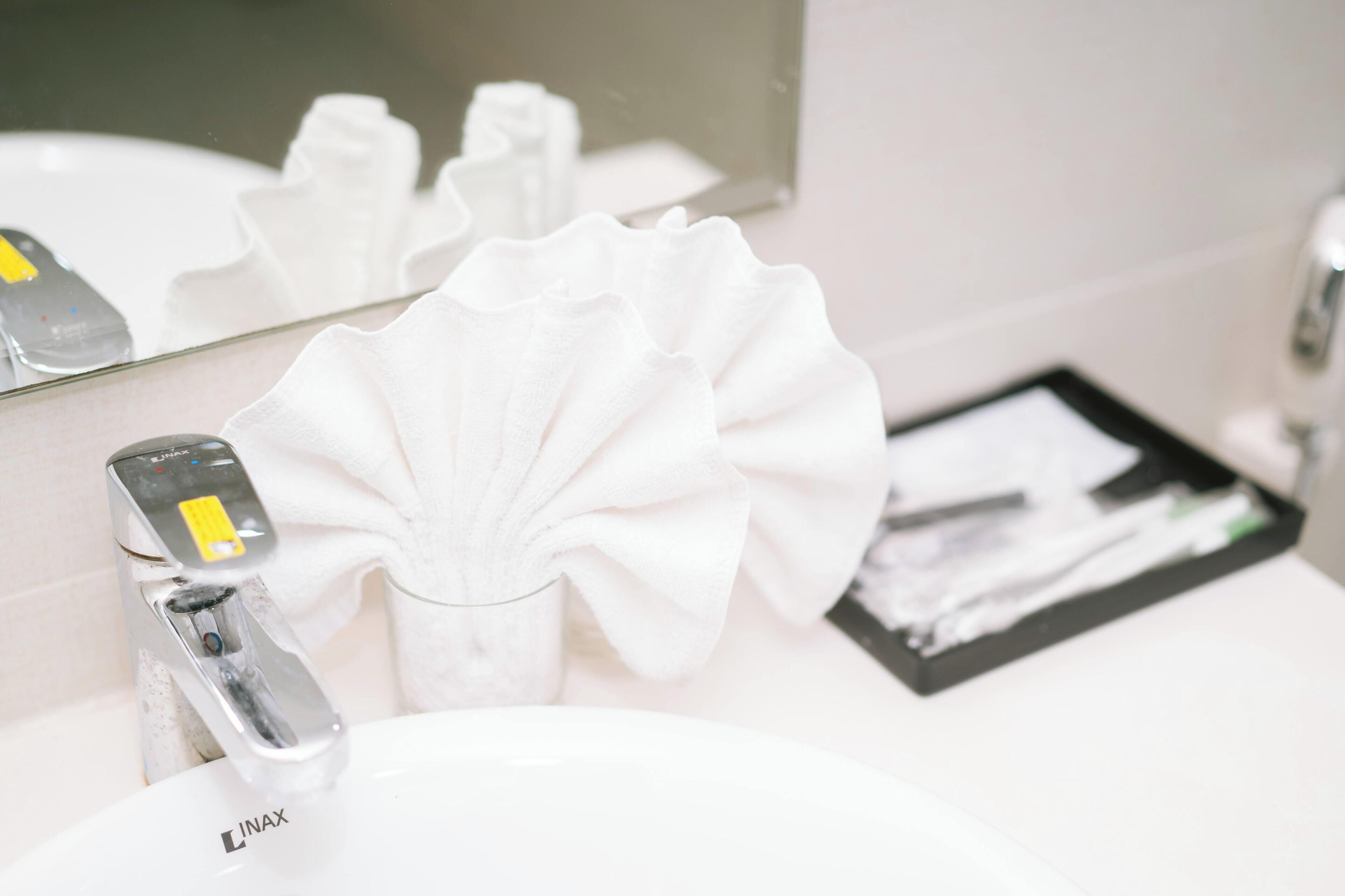 A bathroom sink with a faucet, a mirror, and a tissue box.