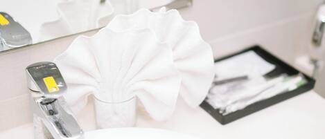 A bathroom sink with a faucet, a mirror, and a tissue box.