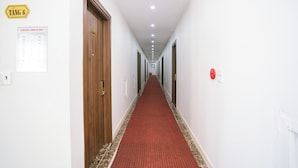 En hotellkorridor med en röd matta, trädörrar och en skylt som visar att det är rum nummer 601.