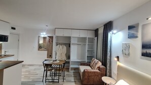 A modern living room with a dining area, a walk-in closet, and a kitchenette. - Monfort A (Bansko)