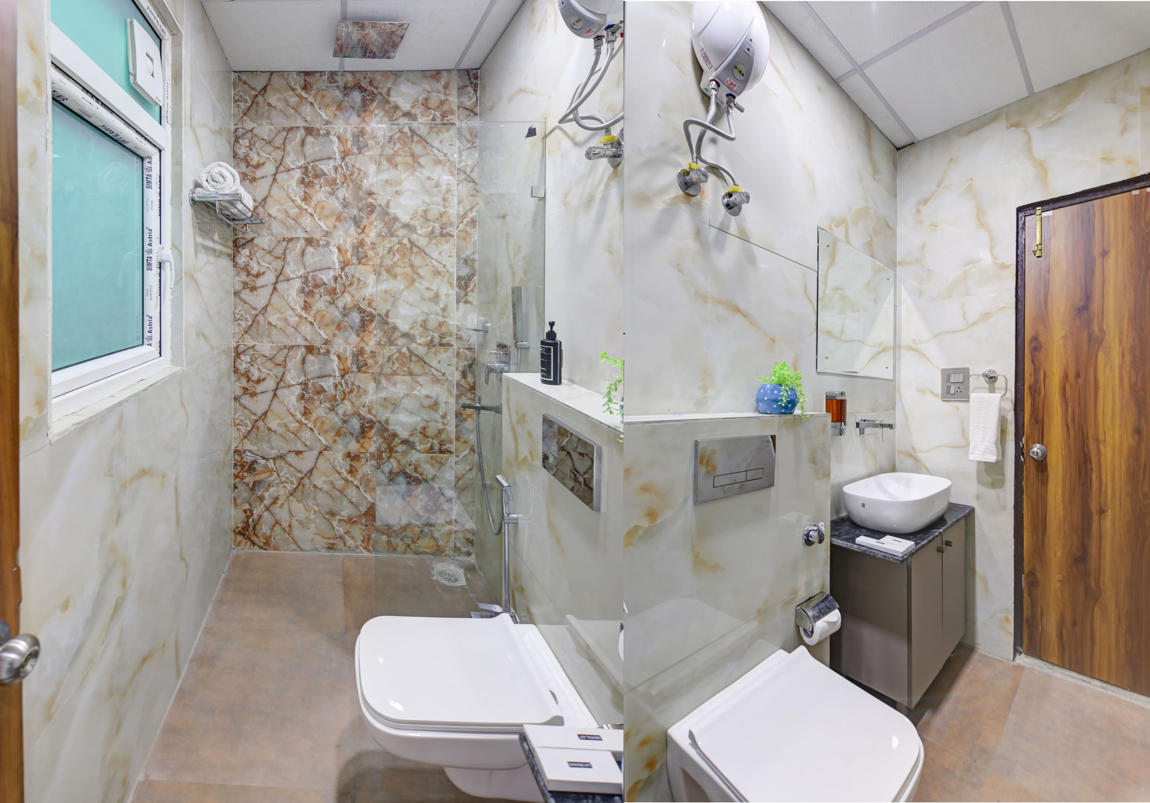 Baño con dos inodoros, un lavabo, un espejo y una zona de ducha.