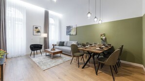 Ein modernes Wohnzimmer mit Essbereich, ausgestattet mit einer Couch, einem Couchtisch und einem Esstisch für vier Personen.