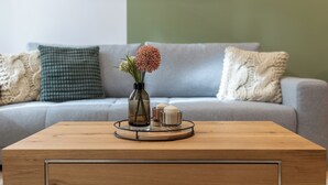 Ein Holztisch mit Blumen in einer Vase und Kerzen auf einem Holzboden.
