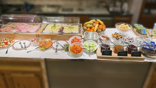 A buffet with various food items including meats, cheeses, fruits, and condiments. - Hotel-Restaurant Zum Kirschbaum (Rottendorf)