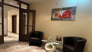 A lobby with two leather armchairs, a glass coffee table, and a painting on the wall. - Hotel-Restaurant Zum Kirschbaum (Rottendorf)