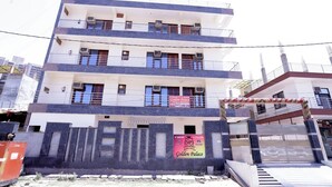 Un immeuble à plusieurs étages doté de balcons, de climatiseurs et d’une enseigne indiquant « Golden Palace Hotel & Banquet ».