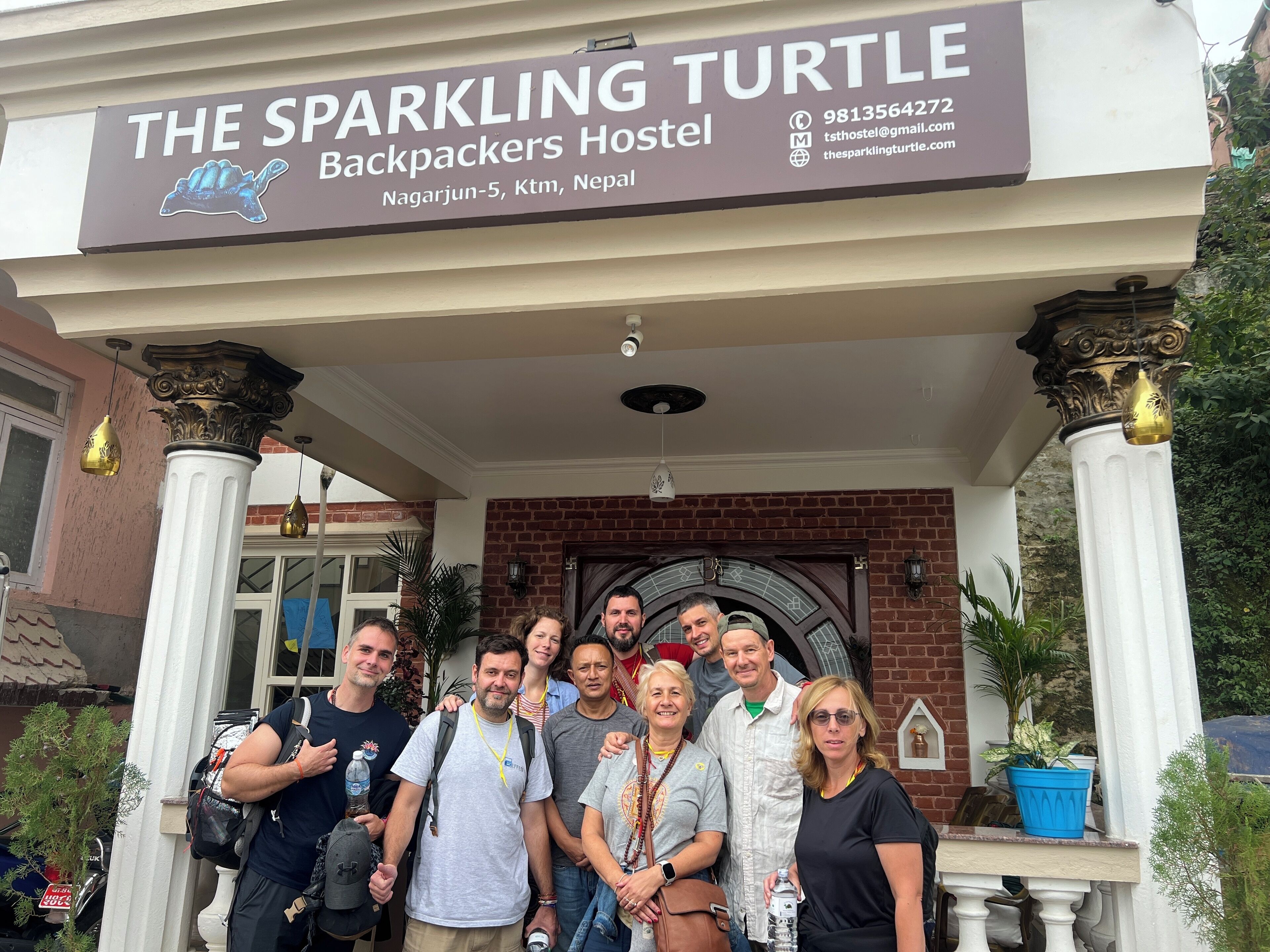 Um grupo de pessoas em frente ao The Sparkling Turtle Backpackers Hostel, localizado em Nagarjun-5, Ktm, Nepal.