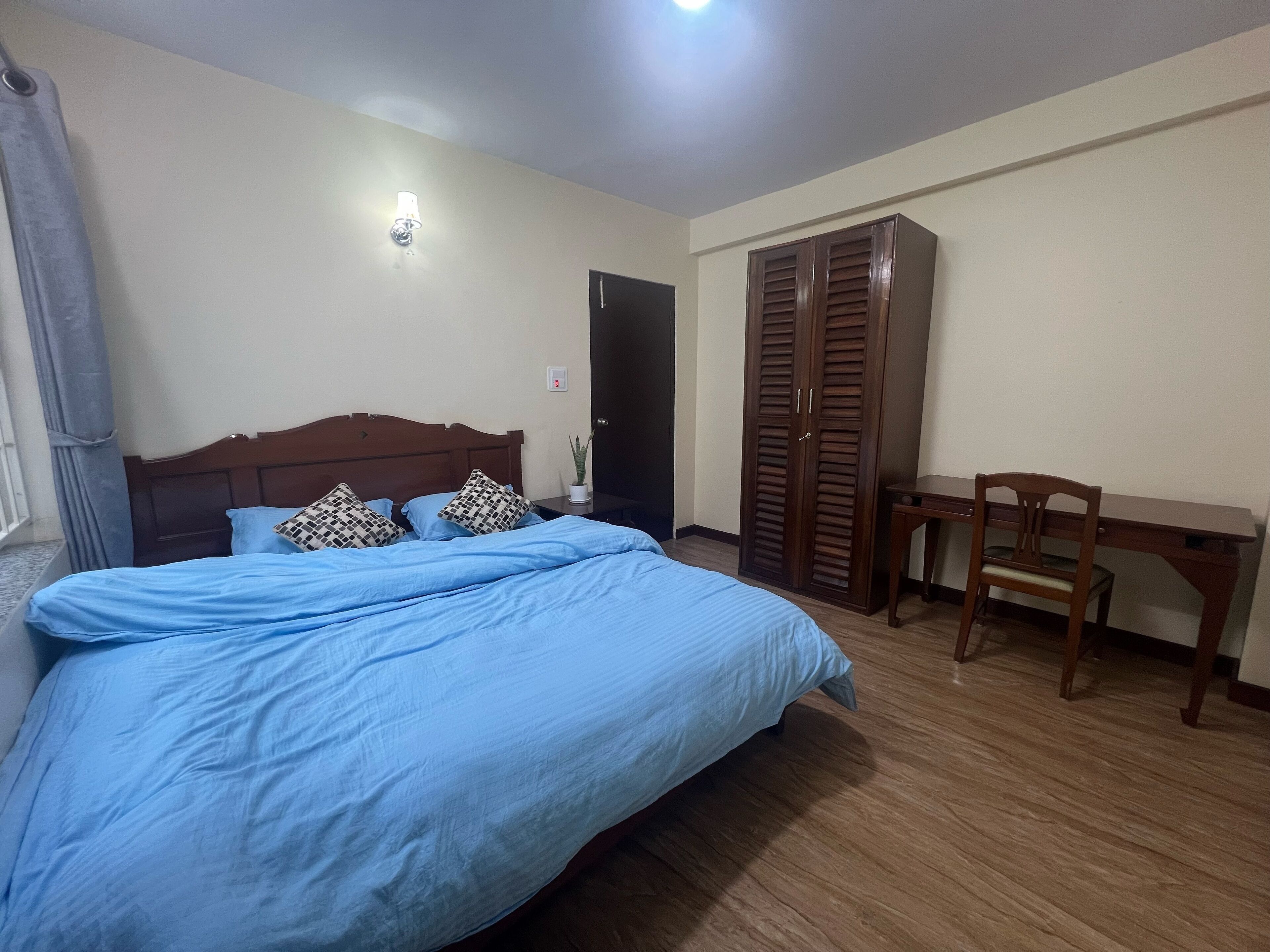 Une chambre à coucher avec un lit, un bureau et une armoire.