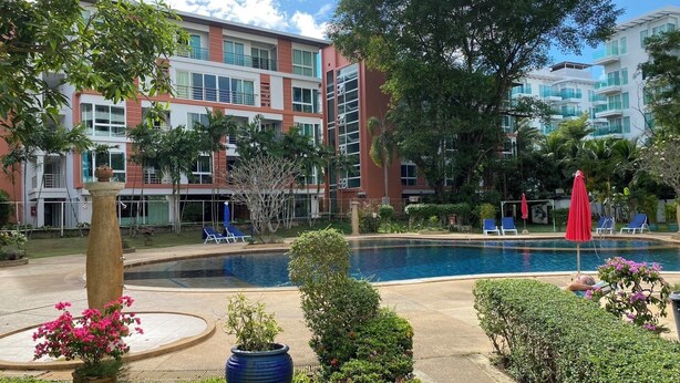 A hotel with a swimming pool, lounge chairs, and a garden area. - Spacieux Studio, Tres Belle vue mer sur la Baie de Patong (Tambon Patong)