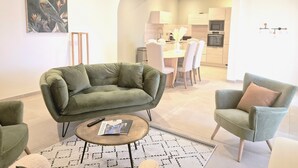 A modern living room with a green sofa, a small coffee table, and a patterned rug.