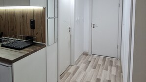 Una cocina moderna con armarios blancos, encimera de madera y lavavajillas integrado.