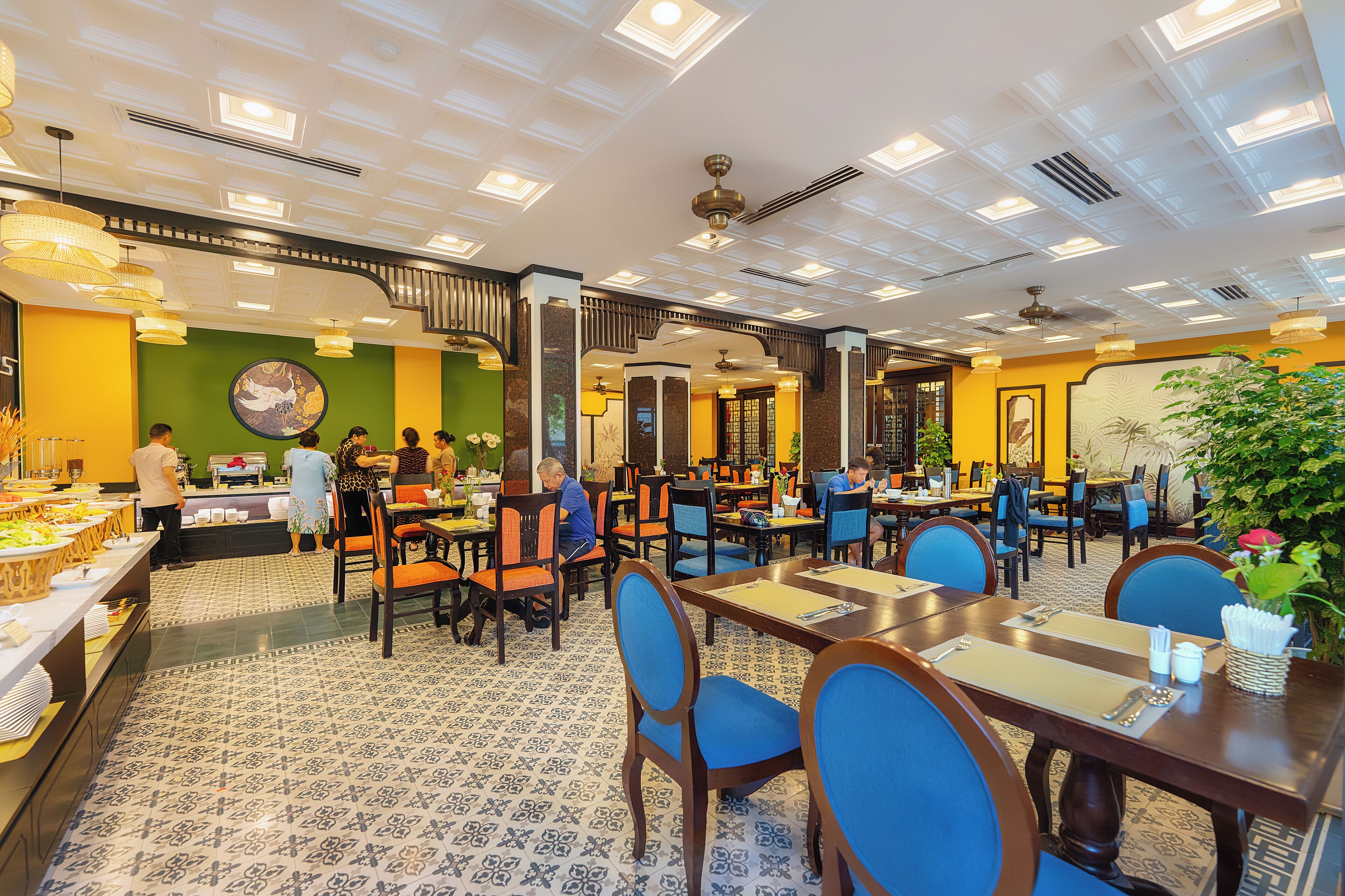 A spacious restaurant with multiple dining areas, a variety of seating options, and a decorative ceiling.