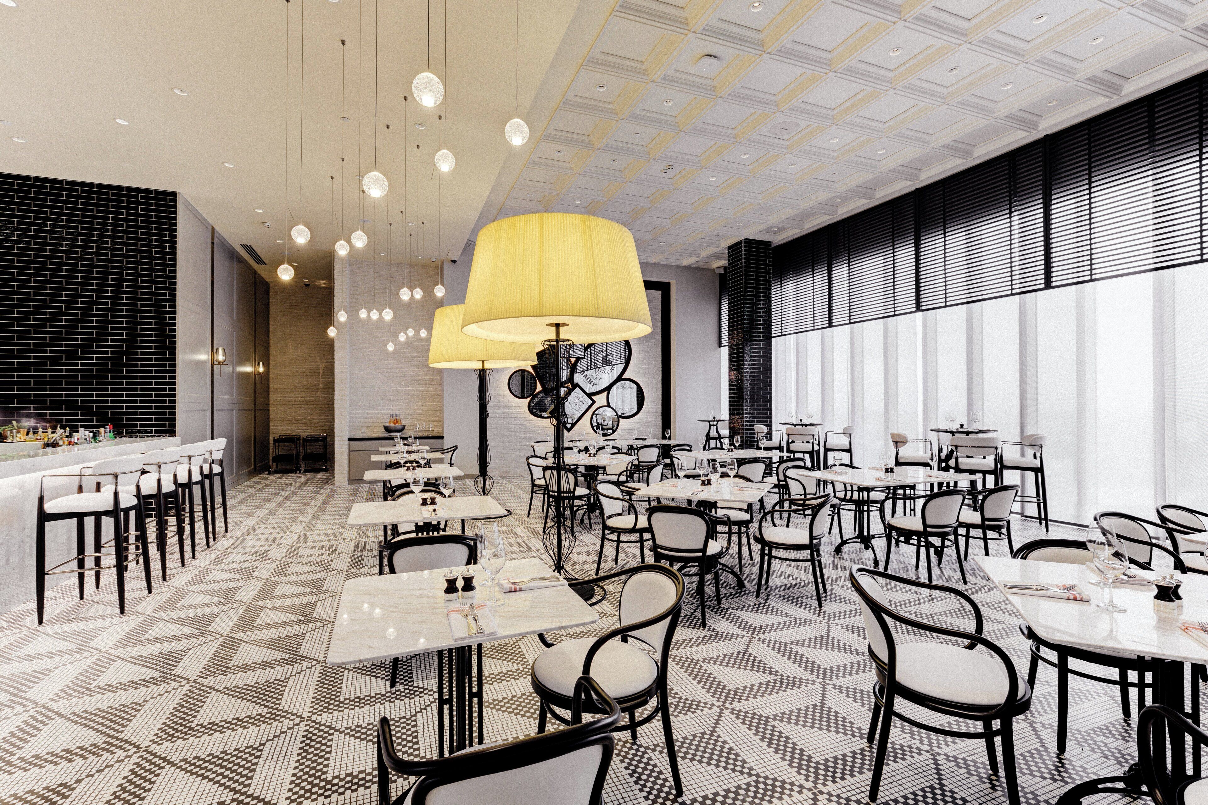 A modern restaurant interior with a patterned floor, black and white chairs, and a yellow pendant light.