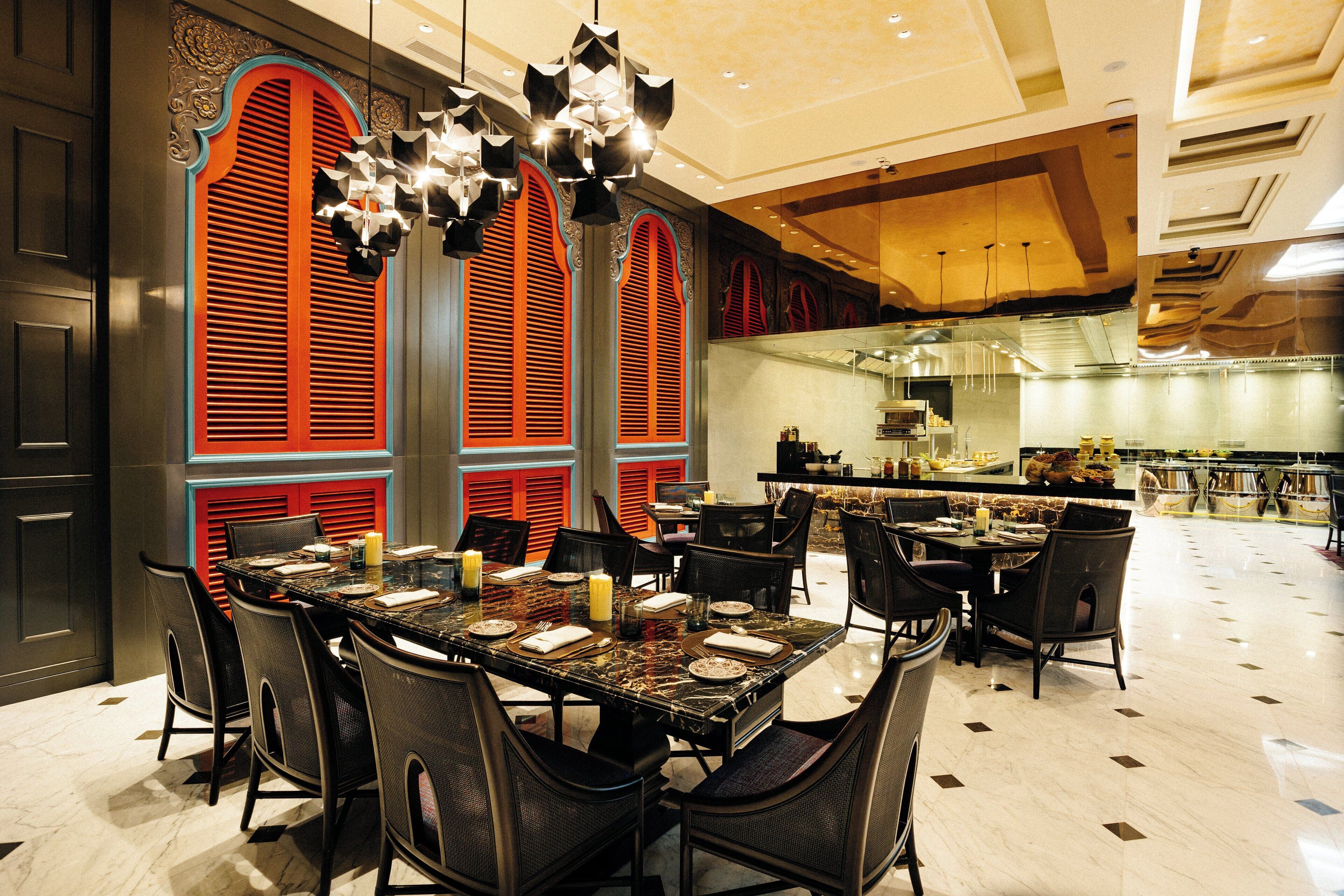 A restaurant with a marble table, black chairs, and red and blue decorative elements.