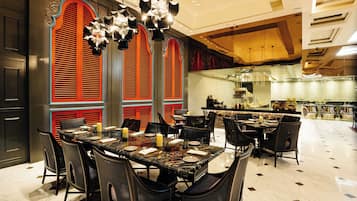 A restaurant with a marble table, black chairs, and red and blue decorative elements.