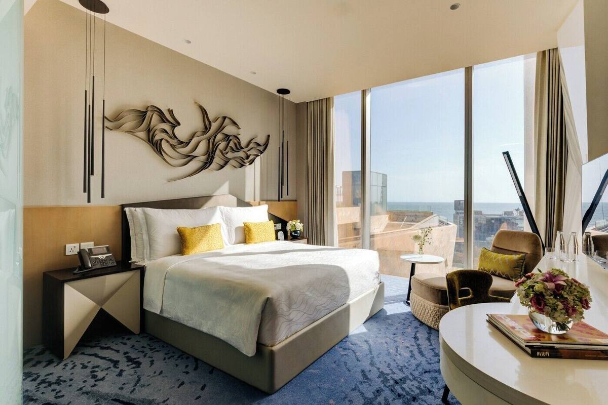 Una moderna camera d'albergo con un letto grande, una scrivania e vista sulla città.