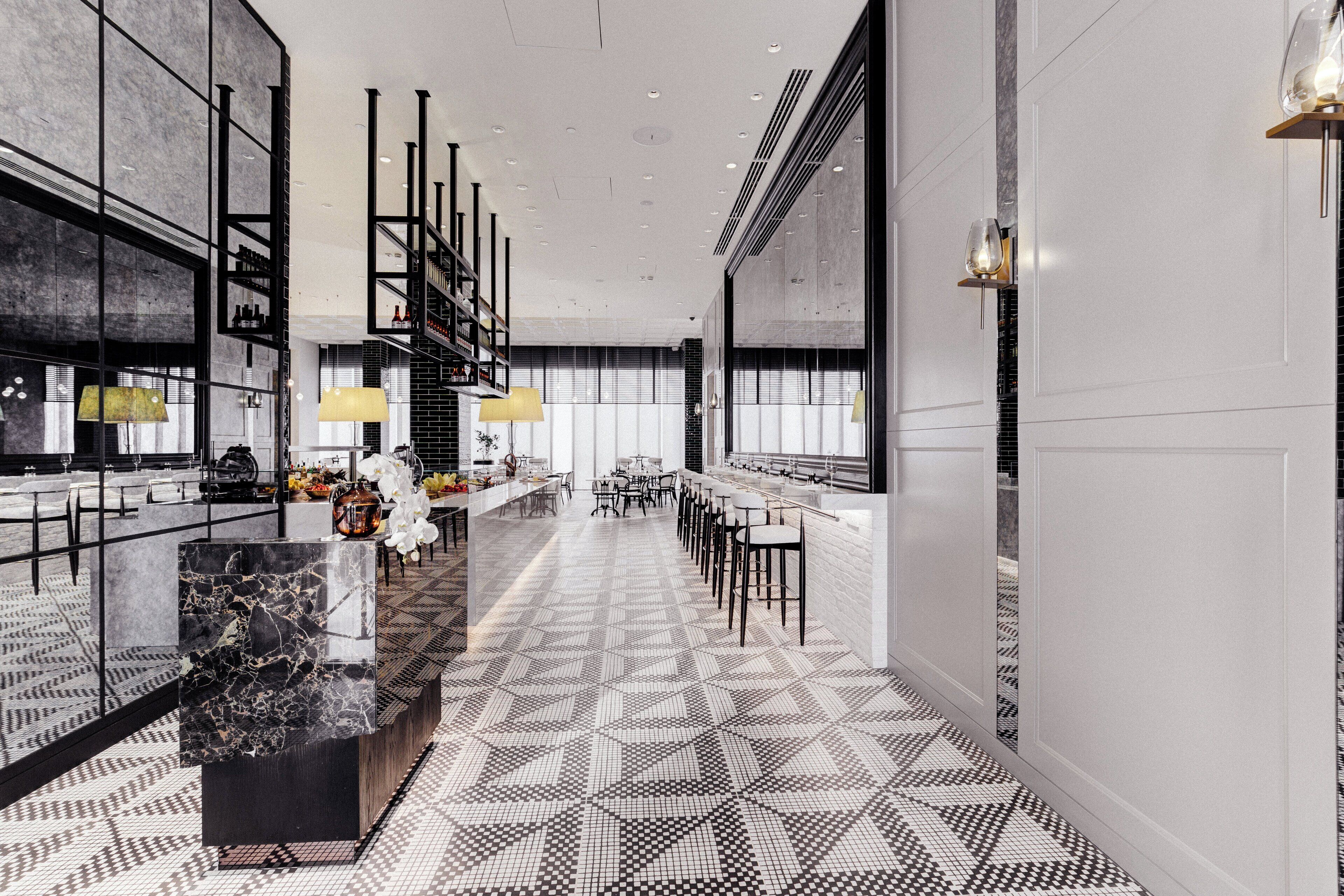 Eine moderne Hotelhalle mit einem geometrisch gemusterten Boden, einer zentralen Sitzecke mit Tischen und Stühlen sowie einer Bar mit einer hohen Ablagefläche für Flaschen.
