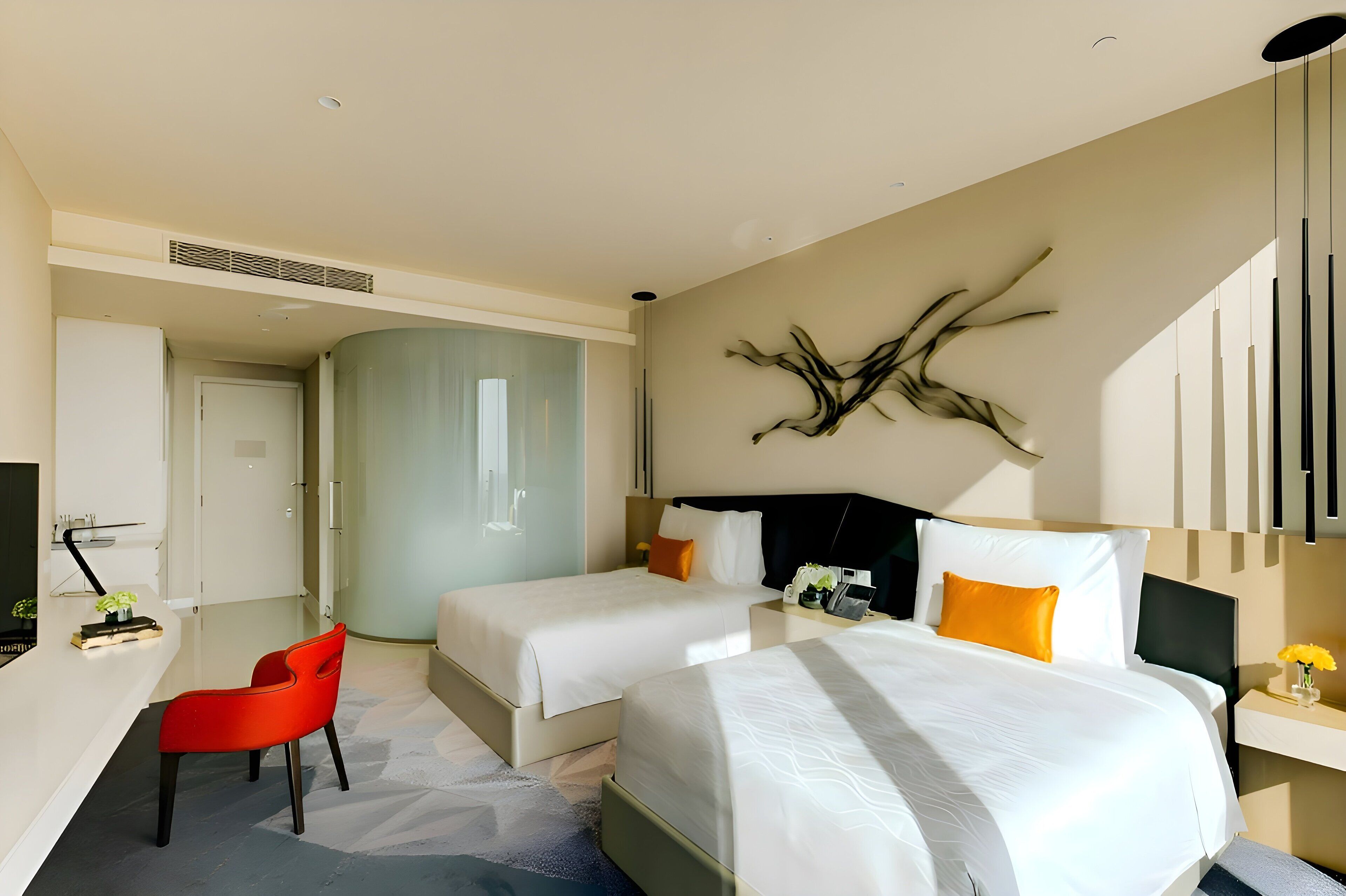 Une chambre d’hôtel avec deux lits, un bureau, une chaise et un élément décoratif mural.