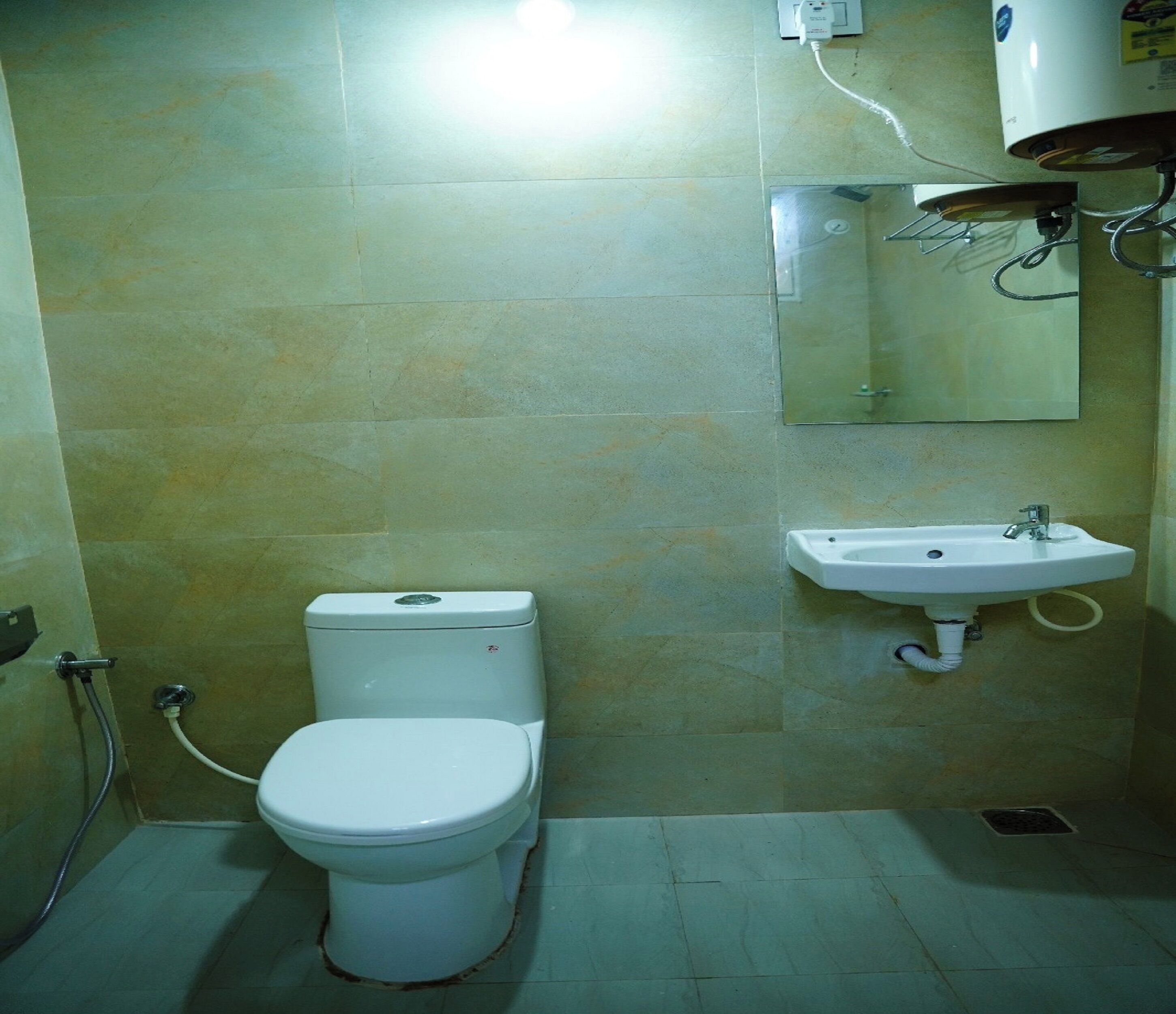 A small bathroom with a toilet, a sink, and a mirror.