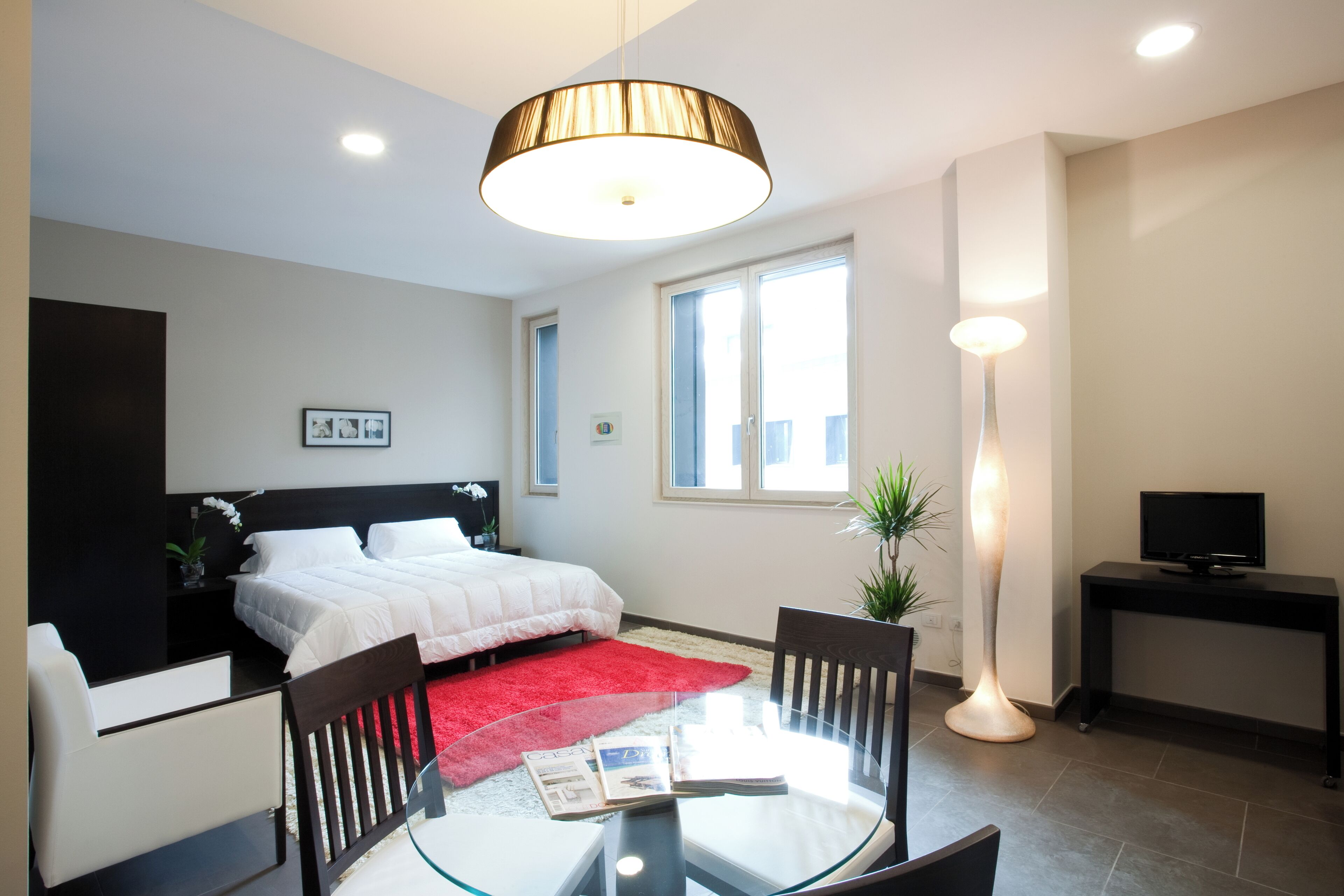 A modern bedroom with a bed, a desk, and a chair.