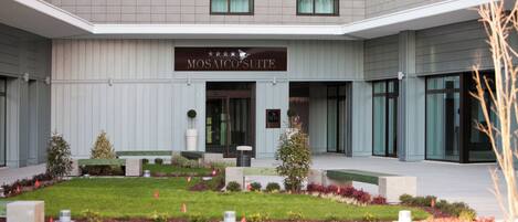 A modern hotel exterior with a sign reading "Mosaic Suite".