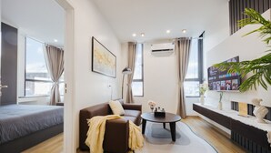 Un salon moderne avec un canapé, une table basse et un téléviseur fixé au mur.