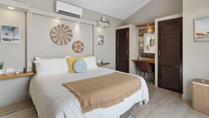 Une chambre moderne avec un grand lit, un ventilateur de plafond, un climatiseur, un bureau et une chaise.