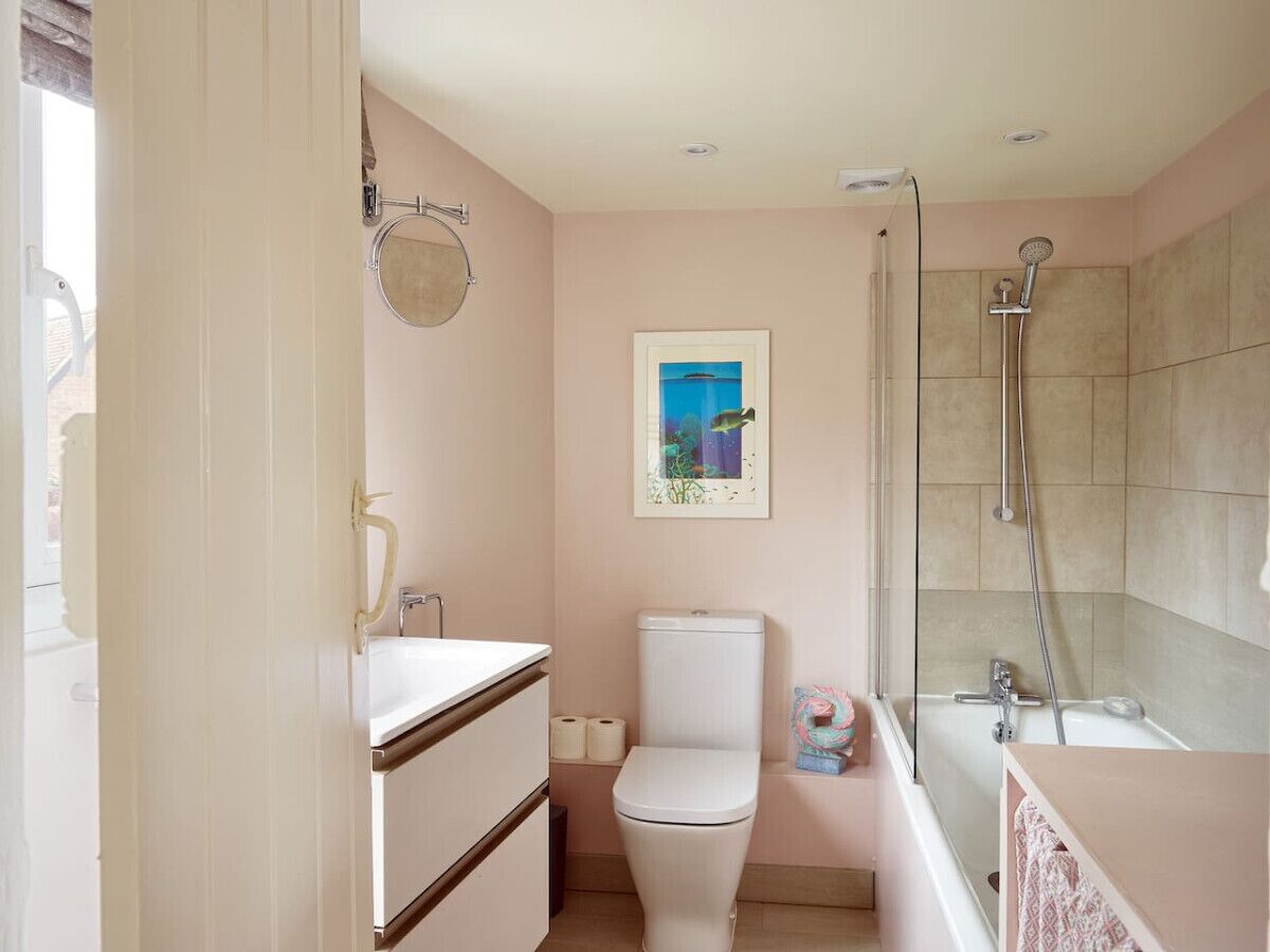 Une salle de bain avec des toilettes, un lavabo et une douche.