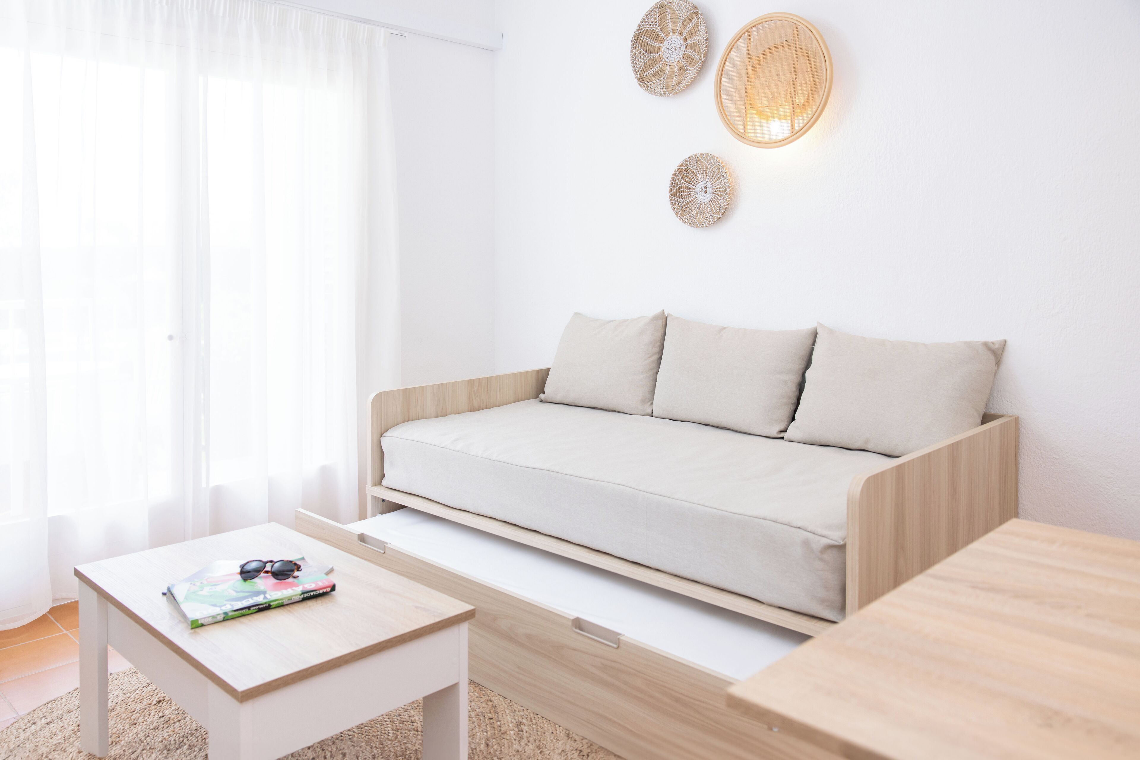 A modern living room with a sofa, a coffee table, and a wall-mounted light fixture.
