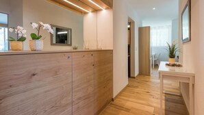 Un moderno vestíbulo de hotel con suelo de madera, una recepción y plantas en macetas.