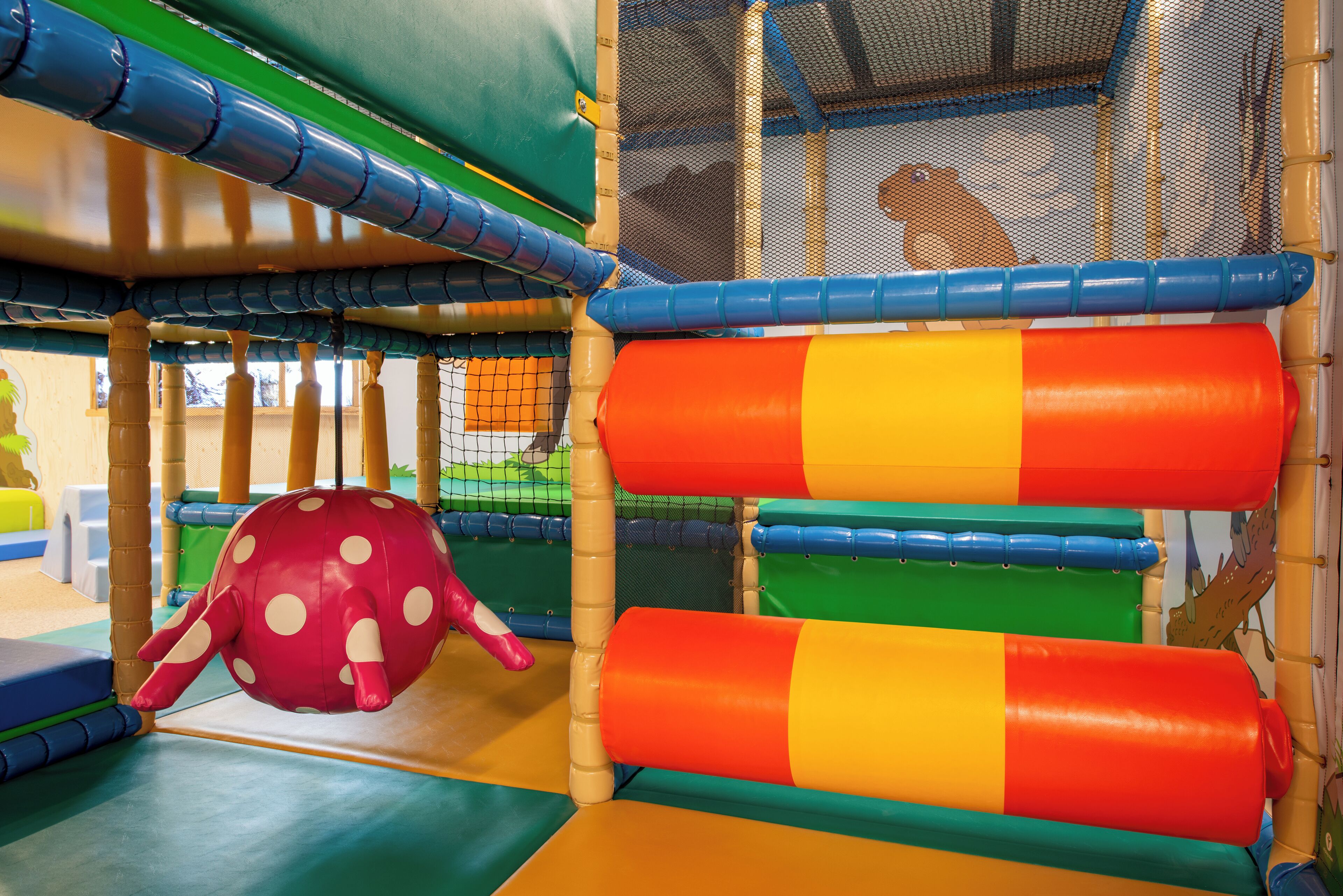 A play area with colorful play structures and a netted enclosure.