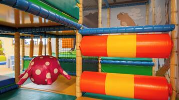 A play area with colorful play structures and a netted enclosure.