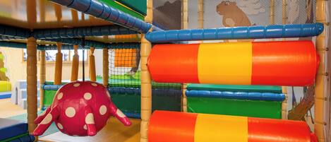 A play area with colorful play structures and a netted enclosure.