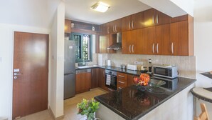 Una cocina moderna con armarios de madera, electrodomésticos de acero inoxidable y una isla central.