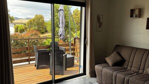 Una sala de estar moderna con un amplio ventanal corredizo que da a un patio exterior.