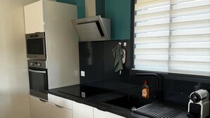 Una cocina moderna con lavavajillas, horno y un cartel que indica 'PLACE De l'Aperto'.