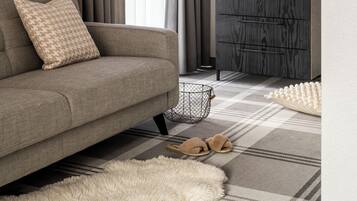 A modern living room with a sofa, a lamp, a side table, and a patterned rug.