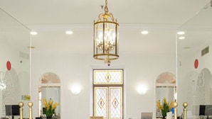 A reception area with a marble floor, a chandelier, and a reception desk. - Hotel Balneario de Marmolejo (Marmolejo)