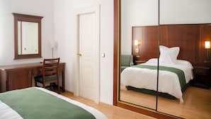 A hotel room with a bed, a desk with a chair, a wardrobe, and a mirror. - Hotel Balneario de Marmolejo (Marmolejo)