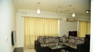 Sala de estar com sofá, mesa de centro e ventilador de teto.
