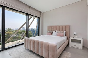 A modern bedroom with a large window, a bed with a headboard, and a nightstand. - Famous Address Beach Resort JBR 1BR (Dubai)