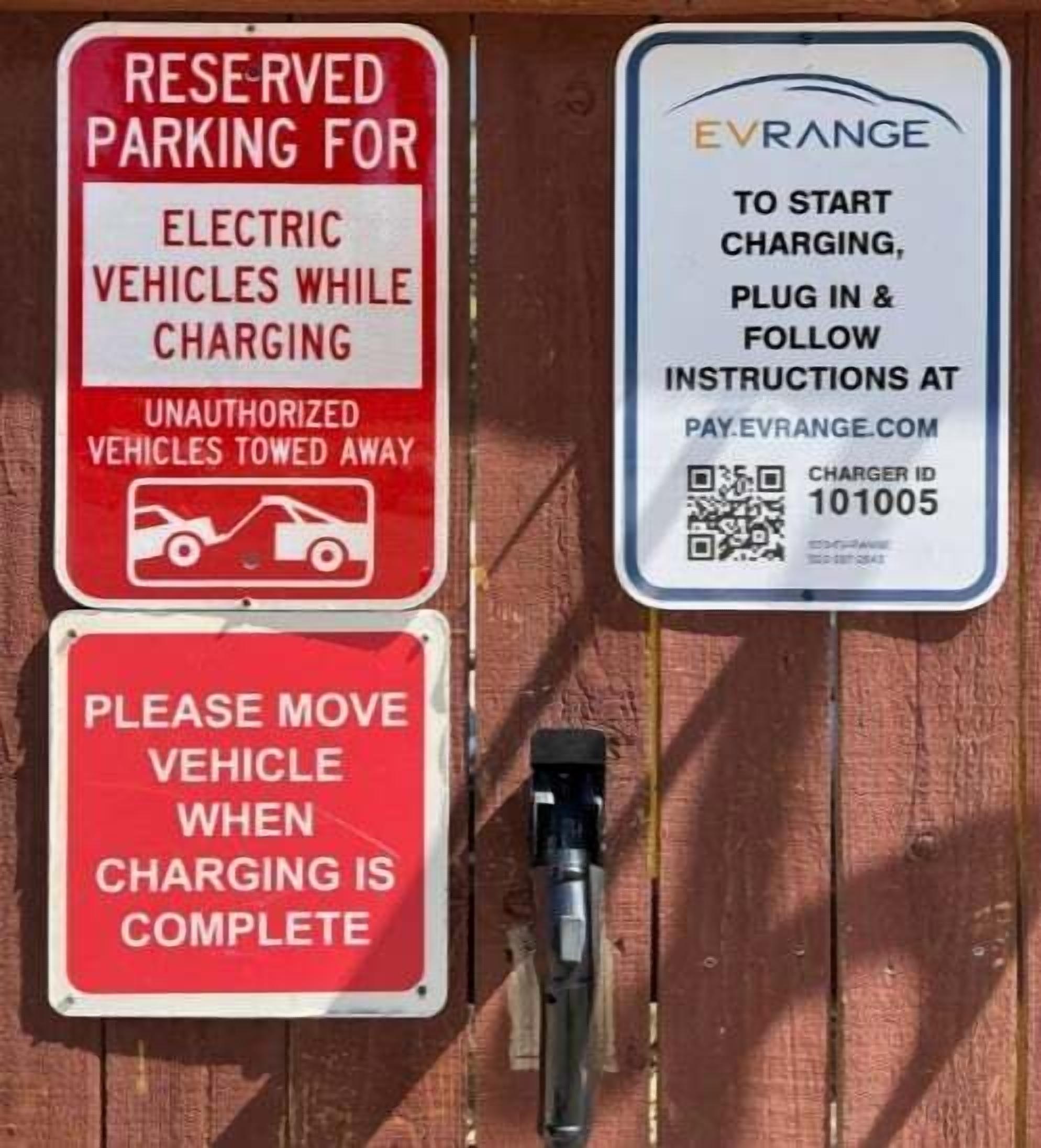 A parking sign for electric vehicles while charging, a QR code for instructions, and a request to move the vehicle when charging is complete.