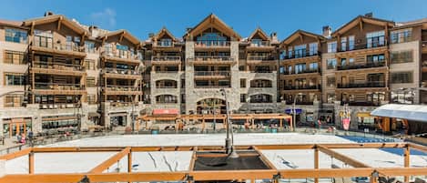 Un hotel de varios pisos con un patio central, zonas de estar al aire libre y fachada de piedra.