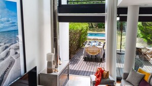 Un interior modern amb una finestra gran que dona a una piscina i un jardí.